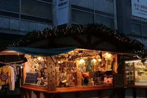 Un chalet de marché de Noël illuminé de guirlandes, avec des créations artisanales exposées