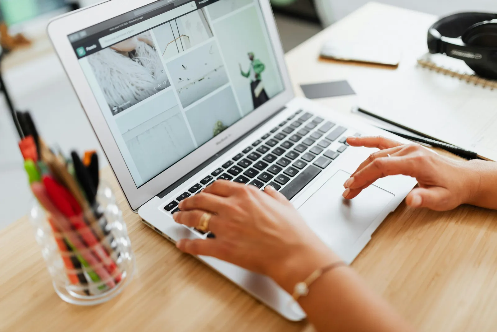 Mains sur un ordinateur portable affichant un site web, sur un bureau en bois