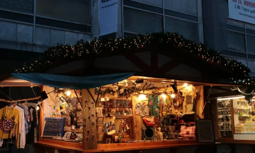 Un chalet de marché de Noël illuminé de guirlandes, avec des créations artisanales exposées